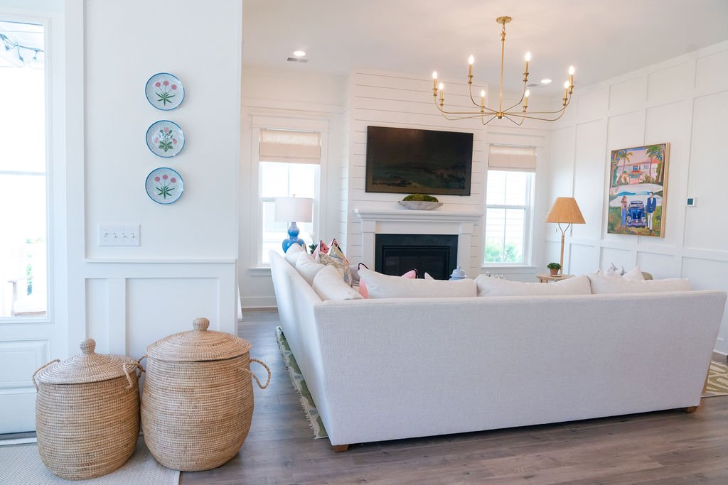 Bright living room with a white sofa, woven baskets, and a fireplace